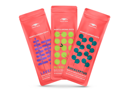 Three coral-red Manta Aroma Dots packets for Lavender, Bergamot, and Eucalyptus scents arranged in a fan shape, isolated on white.