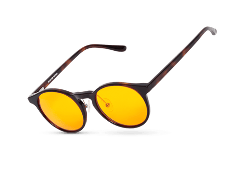Three-quarter floating studio shot of round tortoiseshell blue light blocking glasses with vibrant yellow lenses, isolated on white.