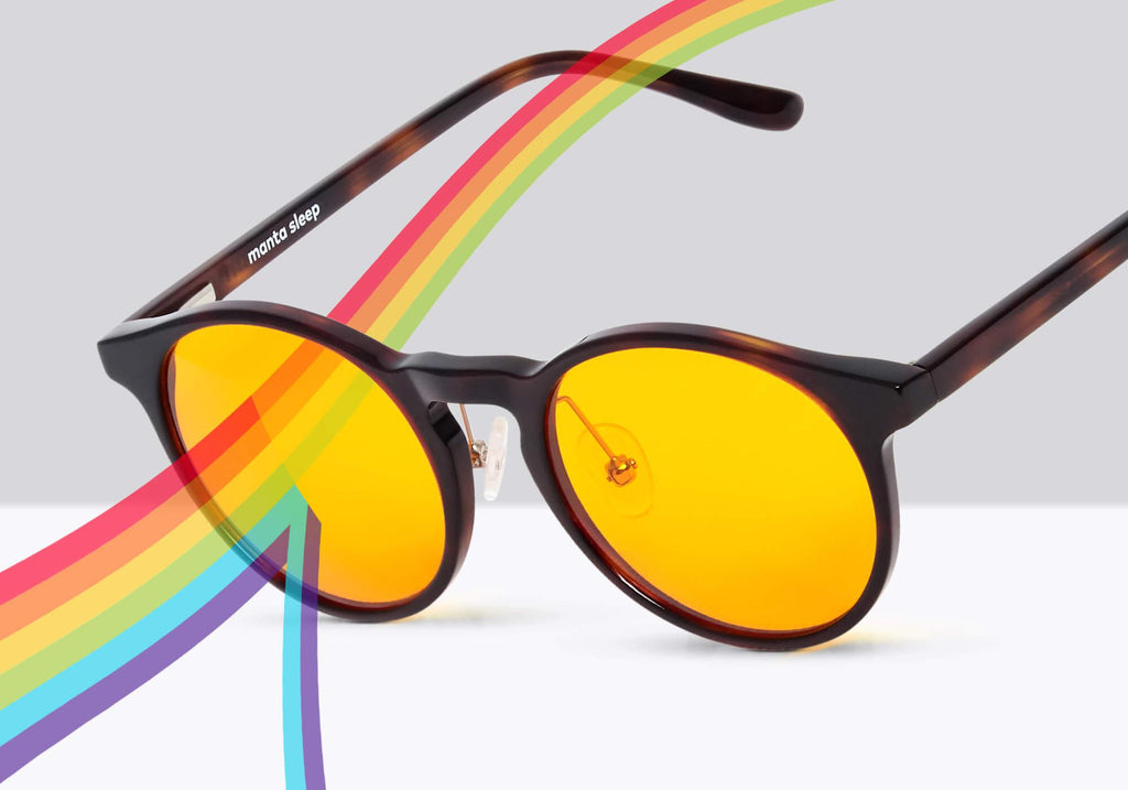 Manta glasses with yellow lenses filtering a rainbow light beam, splitting blue and purple rays downward.
