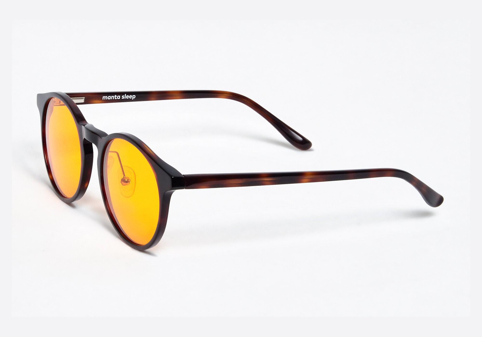 Side view of round tortoiseshell glasses with yellow lenses, showing the slim frame construction against a clean white background.