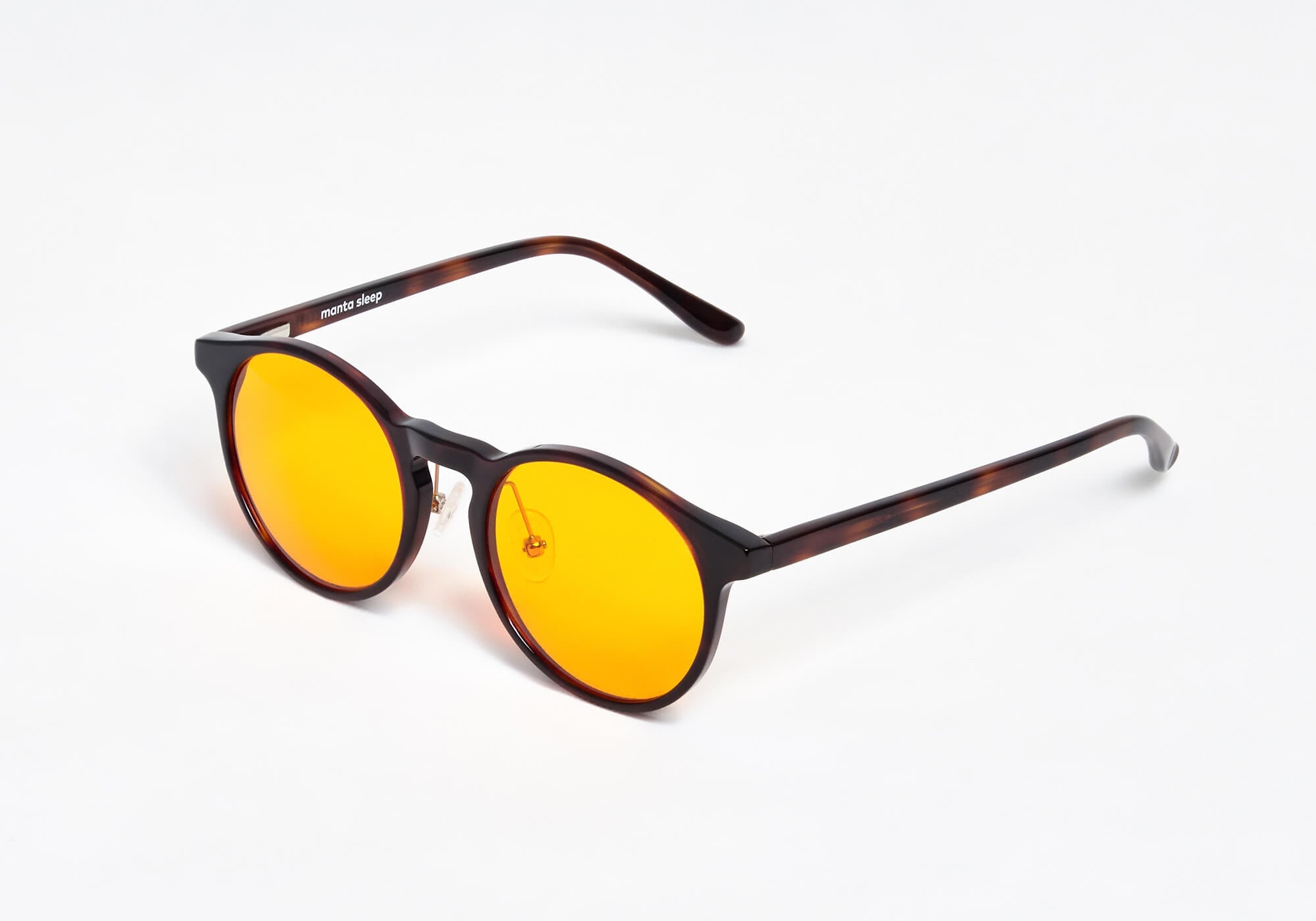Perspective studio shot of round tortoiseshell glasses with yellow lenses and adjustable nose pads, isolated on a solid white background.