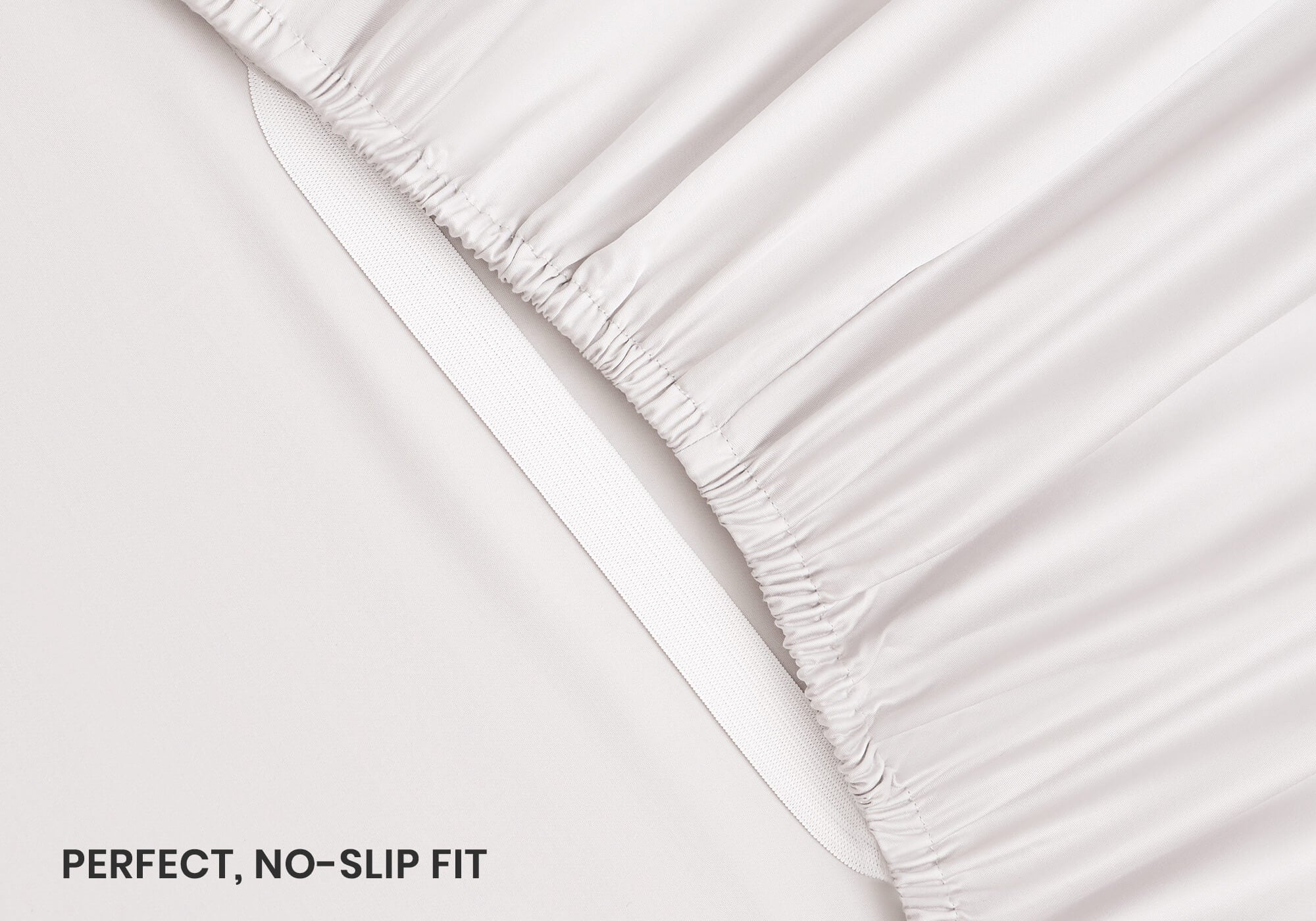 Close-up shot of an elastic corner strap on a white fitted sheet, with text overlay "Perfect, no-slip fit".