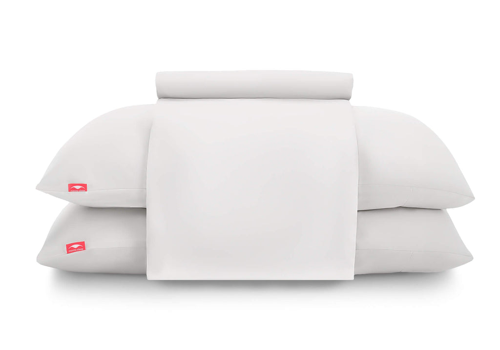 Front view of a flat sheet folded over two stacked pillows in white Manta Sleep cases, isolated on a white background.