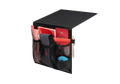 Studio shot of a black and coral Manta Bedside Caddy filled with sleep masks, a notebook, and a pen, isolated on a white background.