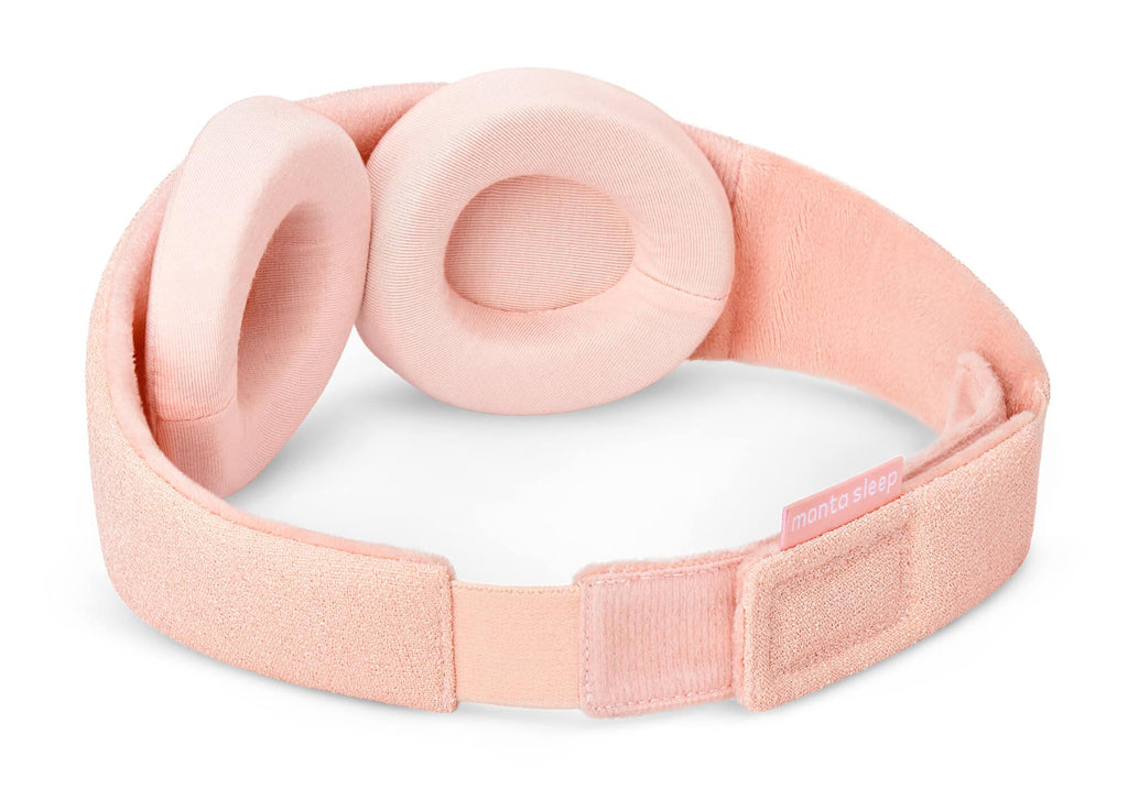 A three-quarter rear perspective of the Sunrise Pink Manta Sleep Mask isolated on a white background. This view highlights the soft, velvety pink inner lining of the strap, the adjustable hook-and-loop rear closure with a pink "manta sleep" tag, and the two detachable, thick pink eyecups.