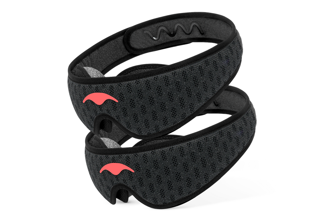 Two Carbon Black Manta Sleep Mask PRO units stacked diagonally, featuring a dark mesh pattern and bright coral Manta Sleep logos.