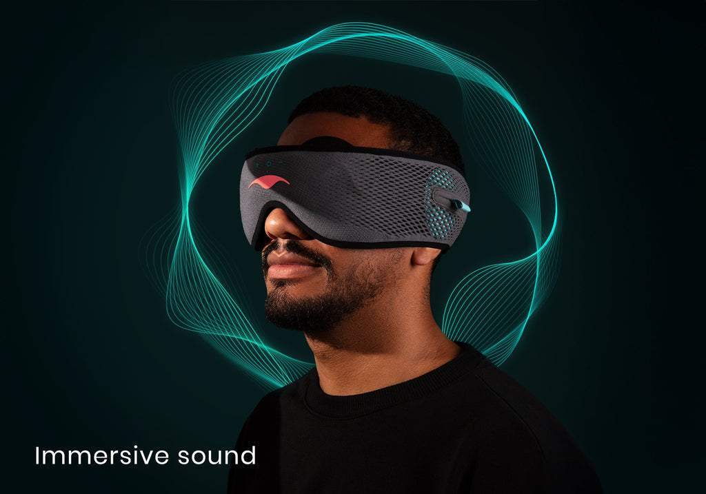 Profile view of a man wearing a grey Manta SOUND Sleep Mask with glowing turquoise soundwaves rippling around his head, captioned "Immersive sound".