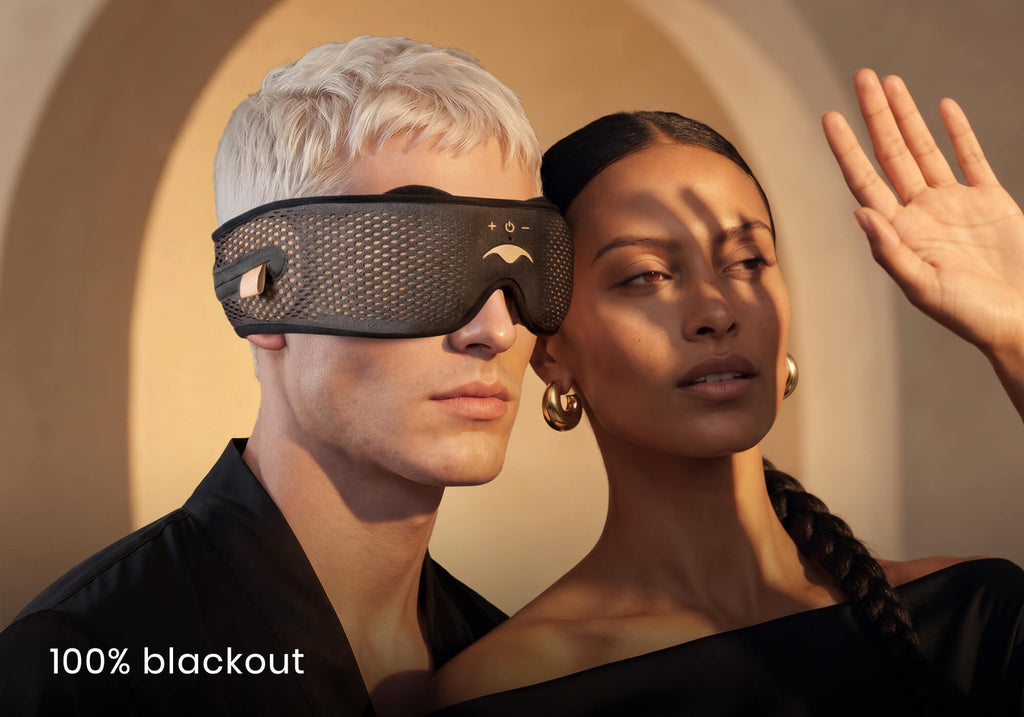 A man wearing a grey Manta SOUND mask stands by a woman shielding her eyes from bright sunlight. Text overlay: "100% blackout".