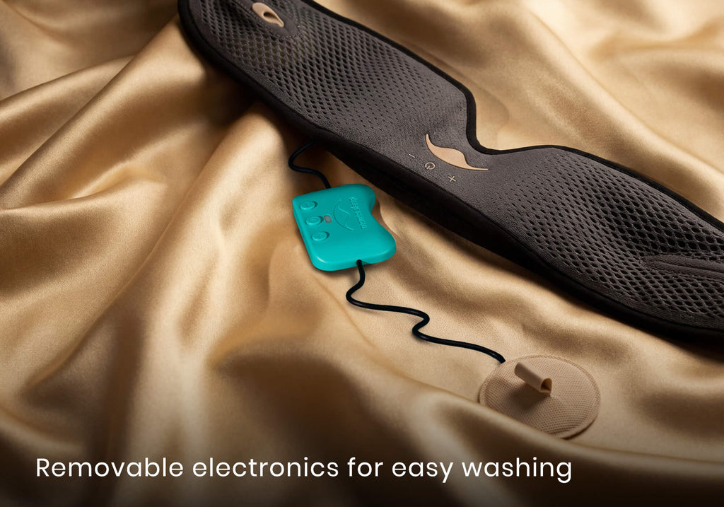 Close-up of a grey mesh mask strap and a detached teal electronic control unit on gold silk fabric. Text: "Removable electronics easy washing".