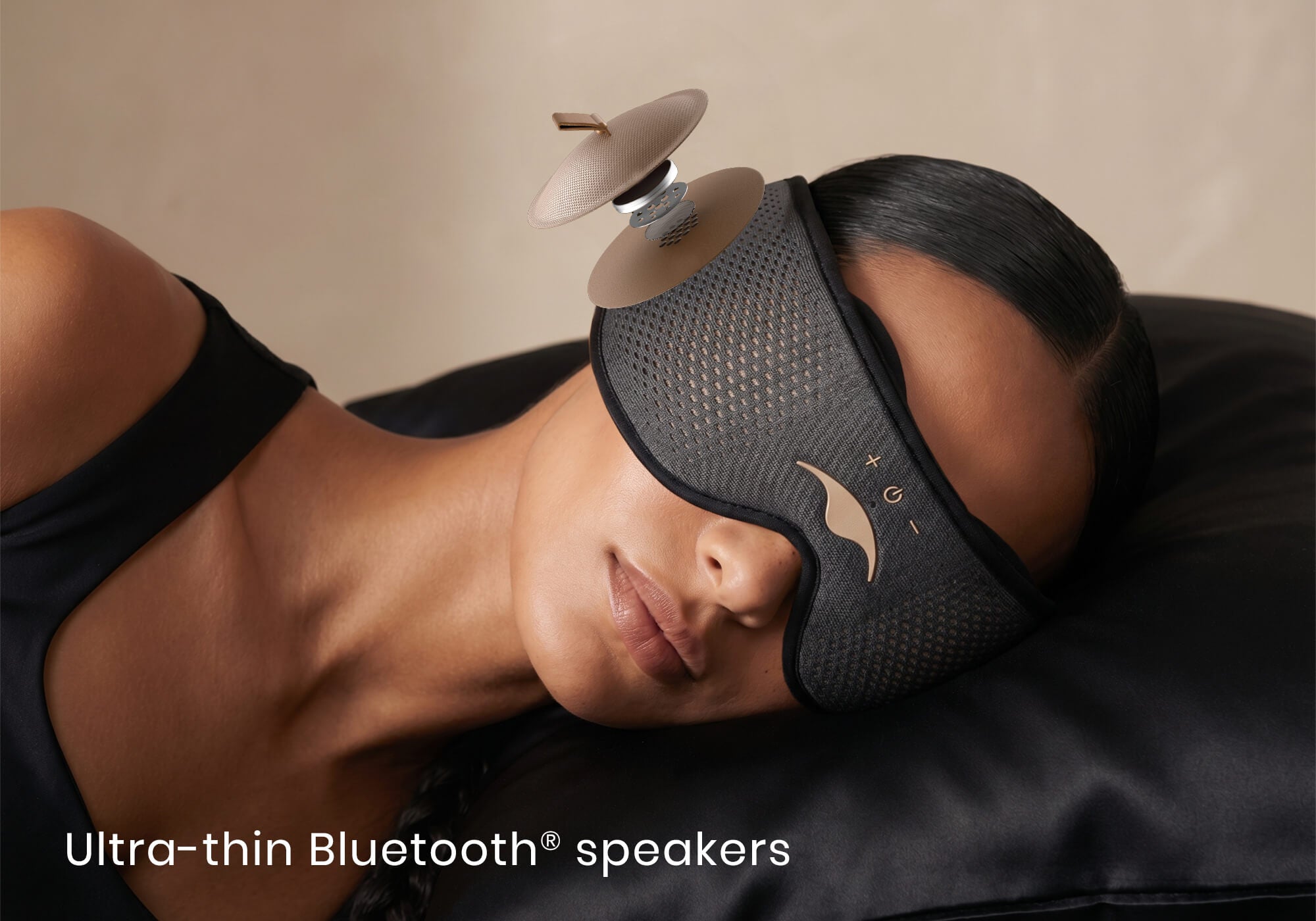 Close-up of a woman lying down wearing a Manta SOUND Sleep Mask, with an exploded diagram overlay of its ultra-thin Bluetooth speaker.