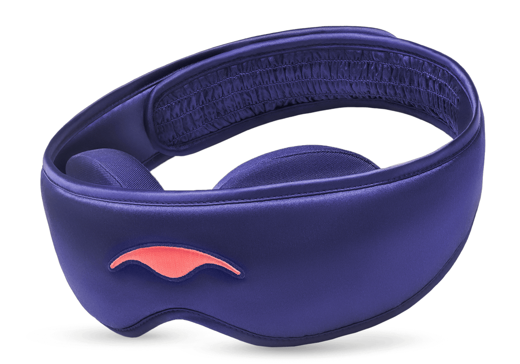Three-quarter studio shot of the Manta SILK Sleep Mask in lustrous purple, featuring an embroidered coral logo and a ruched back strap section.