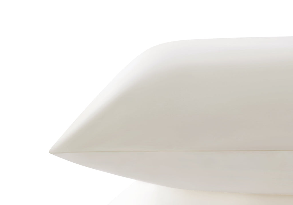 Side profile close-up showing the smooth edge and sleek texture of a pearl white Manta Sleep silk pillowcase.