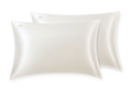 Two pearl white silk Manta Sleep pillowcases overlapping each other, isolated on a clean white background.