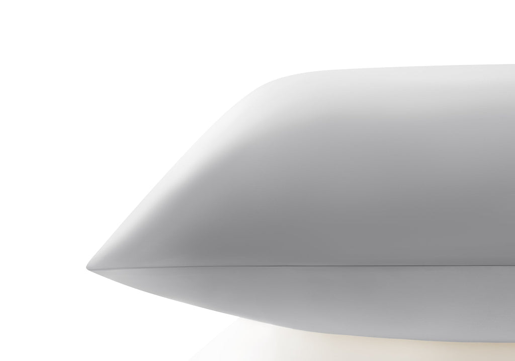 Side profile close-up showing the smooth edge and sleek texture of a crystal silver Manta Sleep silk pillowcase.