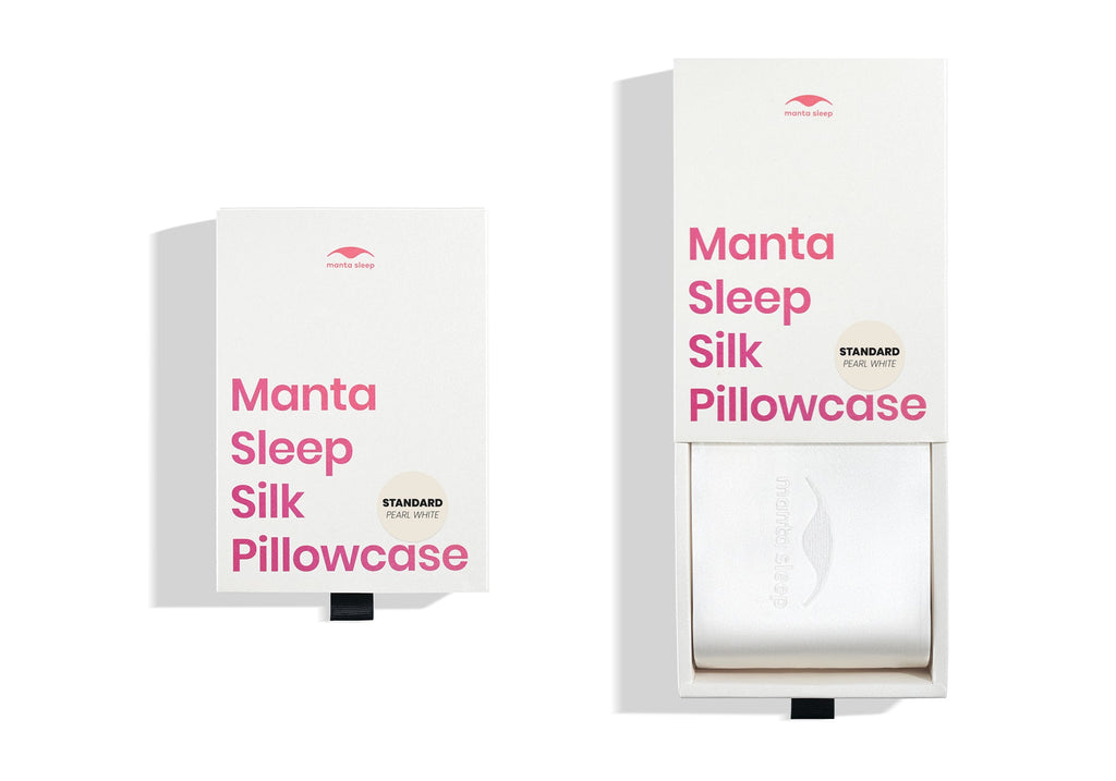 Two white product boxes for the standard pearl white Manta Sleep silk pillowcase, one closed and one pulled open.