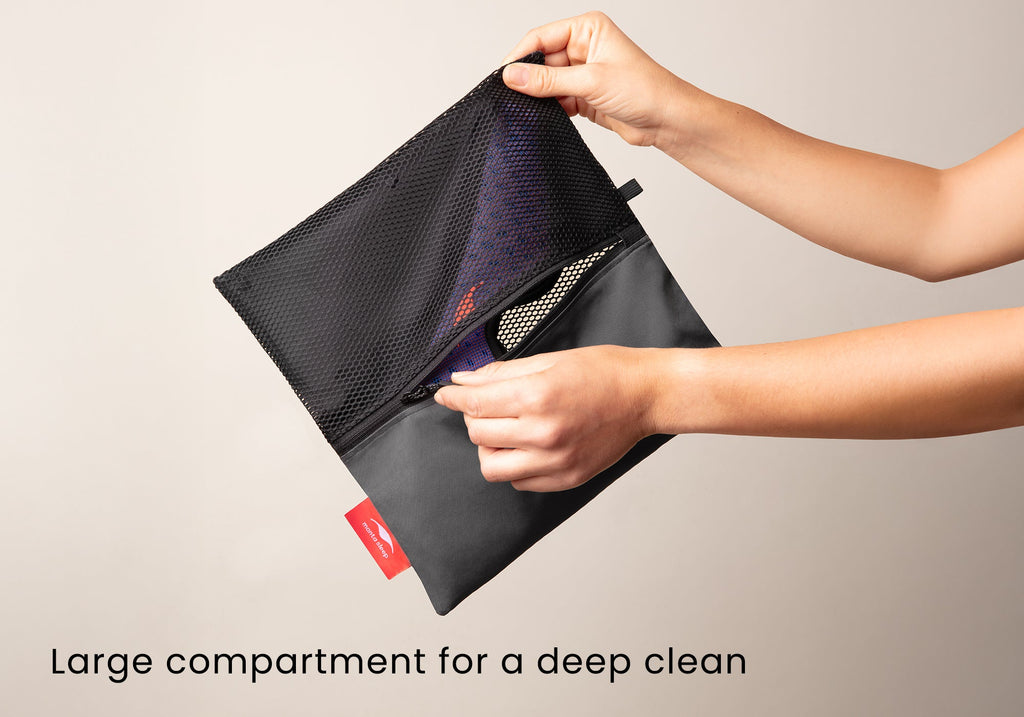 Hands holding the fully expanded laundry wash bag to show the large black mesh compartment designed for machine washing. Text overlay: "Large compartment for a deep clean".