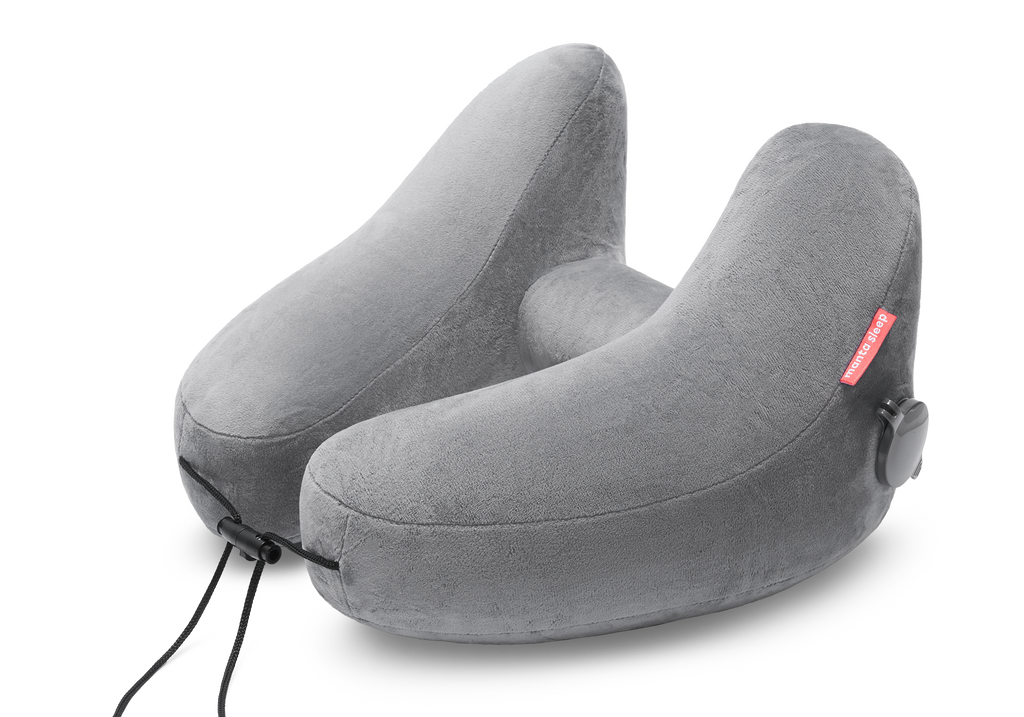 High-angle studio shot of an inflated grey plush Manta Travel Pillow with an adjustable front drawstring cord.