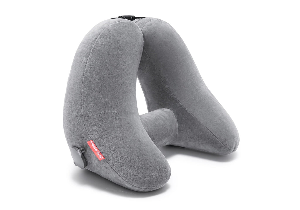 Studio shot of an inflated grey plush Manta Travel Pillow standing upright on a clean white background.